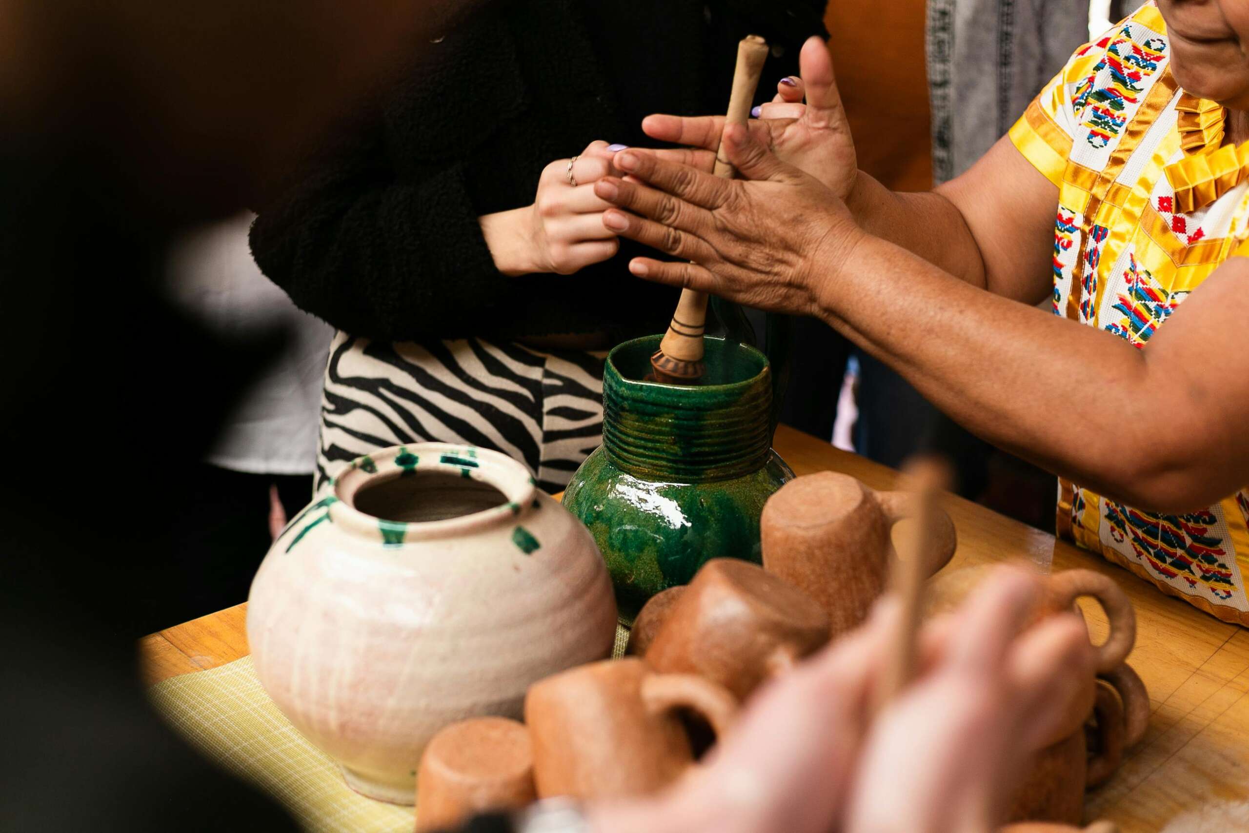 Close-up of artisans crafting handmade pottery in Oaxaca, showcasing local craftsmanship.