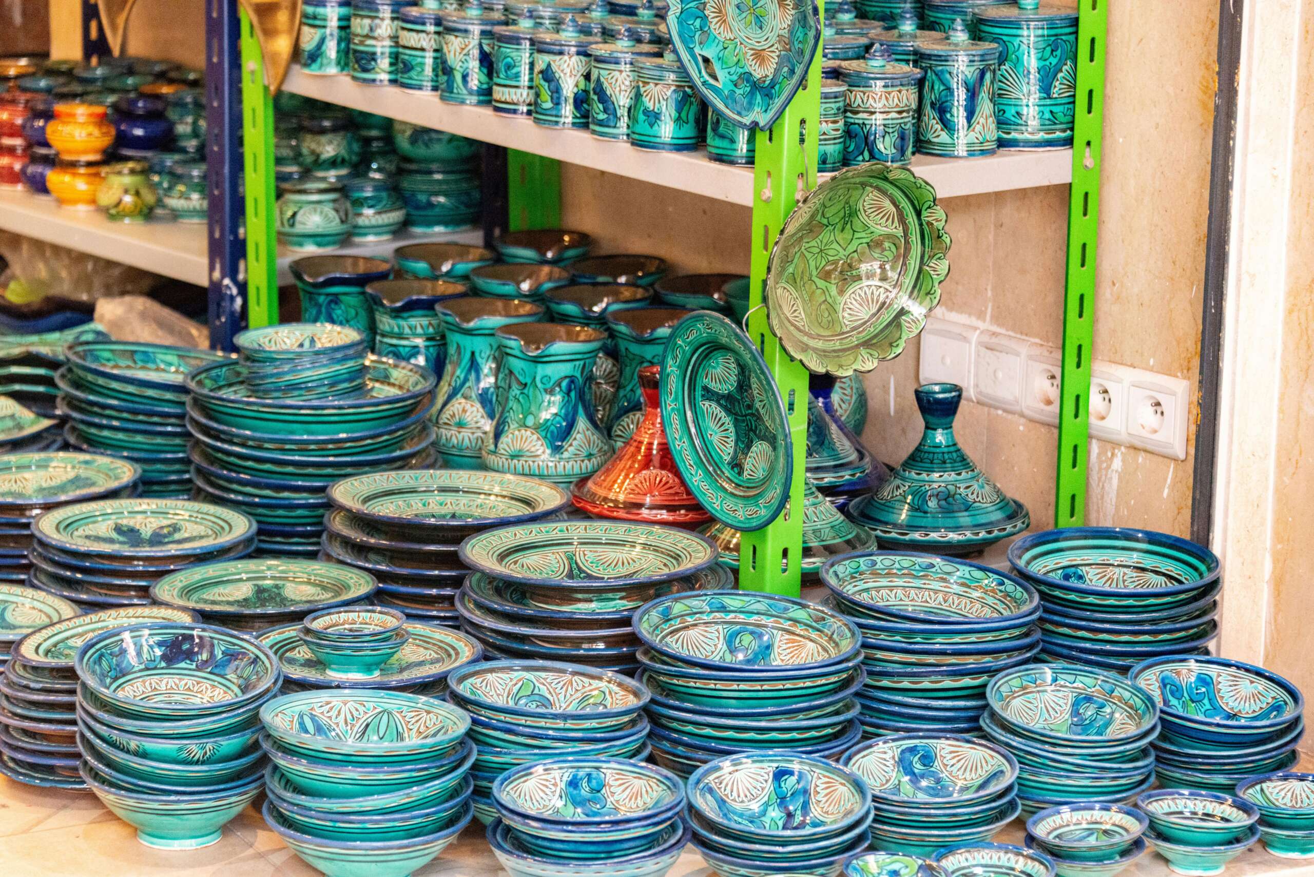 Colorful array of handcrafted pottery and ceramics in a shop setting, showcasing intricate patterns.